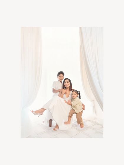 The color version of a beautiful family moment, where a mother is surrounded by her children's love. The bright, airy feel of the studio makes their connection the central focus of this family portrait.