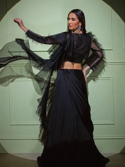 The black feather-sleeve saree in motion, showcasing the dramatic flair of the sleeves and the flowing drape.