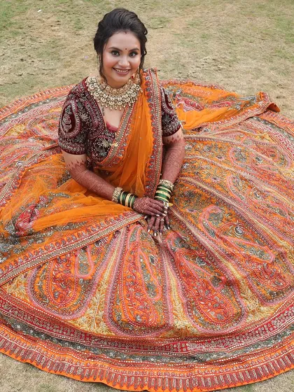 Another stunning shot of the bride's lehenga. The paisley motifs and rich colors are a work of art, and her glowing makeup is the perfect complement.
