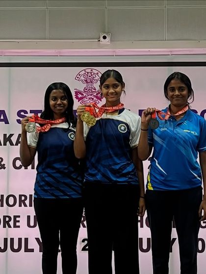 Our national-level Air Pistol women's team on the podium, celebrating their victory and medals.