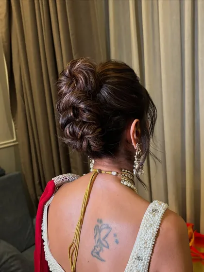 A slightly different angle of the textured updo, highlighting the soft, wispy pieces that give it a romantic feel.