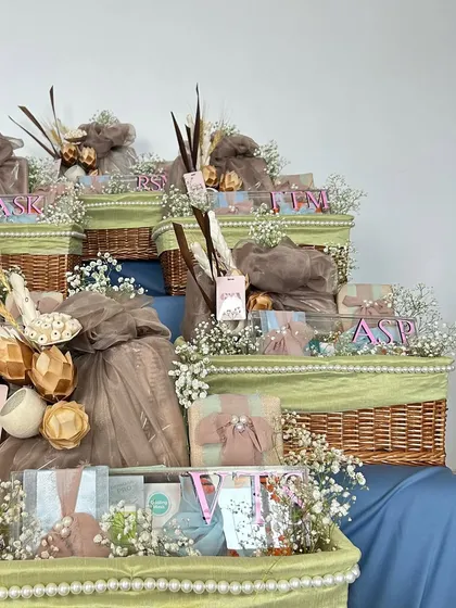 A still shot of the tiered display of personalized wicker hampers. This setup is perfect for baby showers or birth announcements, allowing guests to easily take a beautifully prepared gift.