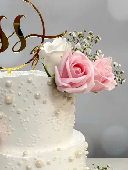 Another angle of the 'S&S' engagement cake, highlighting the beautiful floral arrangement and the elegant gold initial topper.