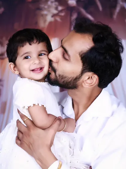 A tender moment between a father and his daughter, captured in a simple and beautiful portrait.