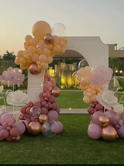 The full view of the whimsical balloon arch against the lush green lawn, setting a celebratory and feminine tone for the bridal shower.