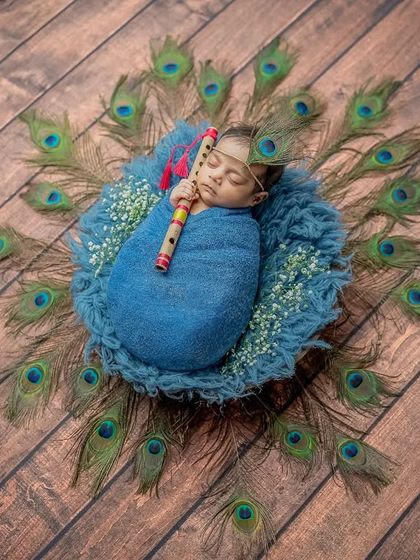 This wide shot shows the full arrangement of peacock feathers creating a magnificent backdrop for our sleeping baby Krishna.