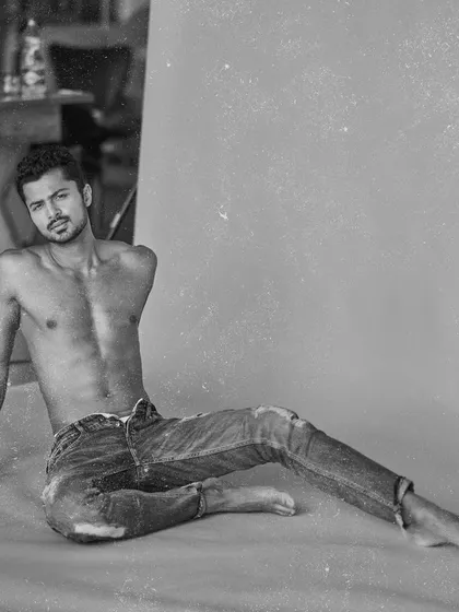 A black and white version of a relaxed, floor-posed studio shot, giving it a classic and moody feel.
