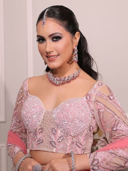 A beautiful portrait of the engagement bride, smiling and radiant in her pink lehenga and diamond jewelry.