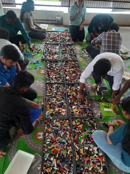 A wide view of participants spread out and building with LEGOs. This shows the ample space and resources we provide for our creative events.