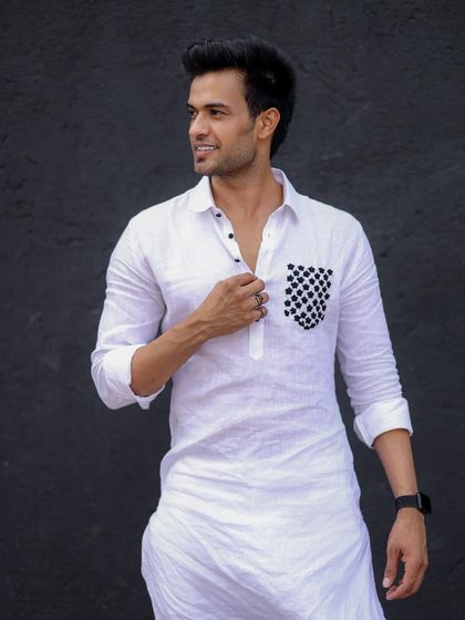 A full-length view of the white linen kurta with a checkered pocket, showing its clean lines and modern silhouette.