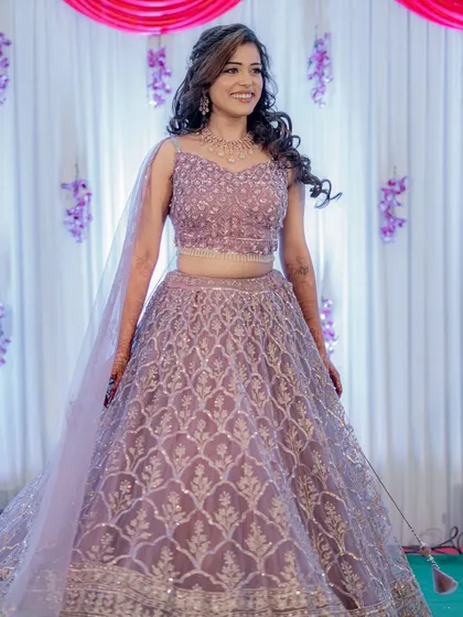 A full-length shot of the bride twirling in her gorgeous lilac lehenga.
