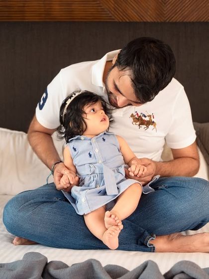 A quiet moment between a father and his baby girl during their at-home photoshoot. These gentle interactions create some of the most precious and heartfelt images.