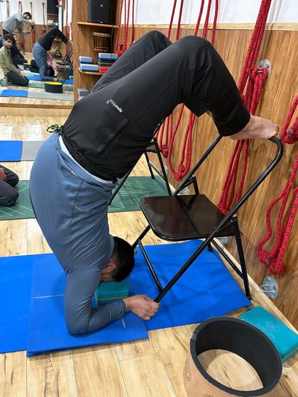 Here, a block is added under the head for extra support in this chair-assisted backbend. This small adjustment can make a big difference in comfort, allowing for a longer, more restorative hold.