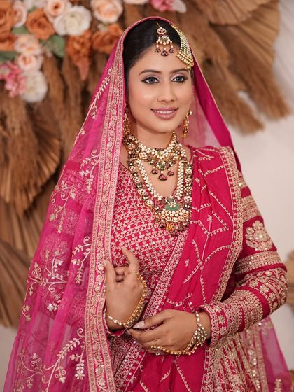 A complete bridal look featuring a heavy, gold-plated Kundan necklace, haath phool, and maang tikka, all available for rent.