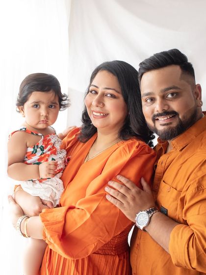 A bright and happy family portrait. The coordinated orange outfits add a vibrant and cheerful energy to the photo.
