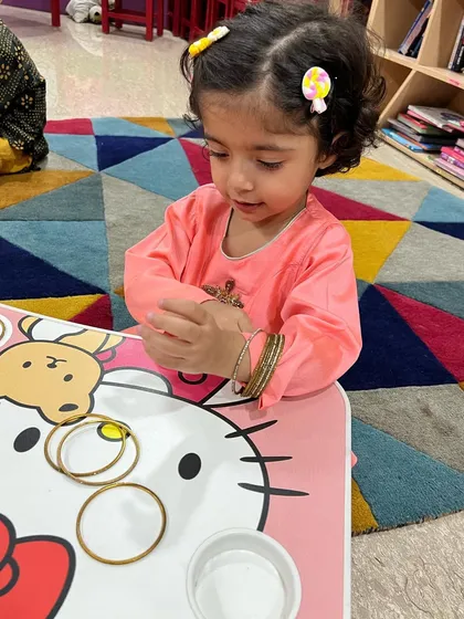 This little girl is exploring bangles during our Diwali celebrations. We incorporate sensory play and traditional items to make the festival experience rich and tangible for the toddlers.