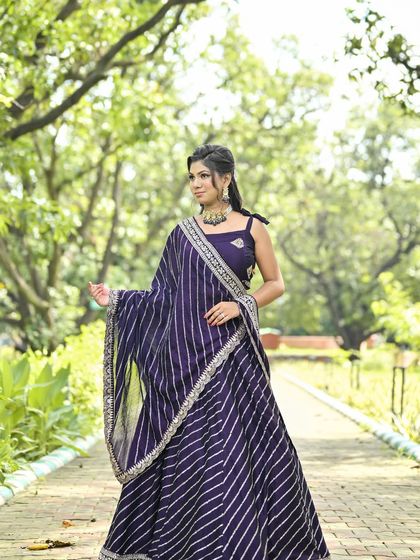 A full-length shot of the purple leheriya lehenga, showing how the striped pattern creates a tall, graceful silhouette.