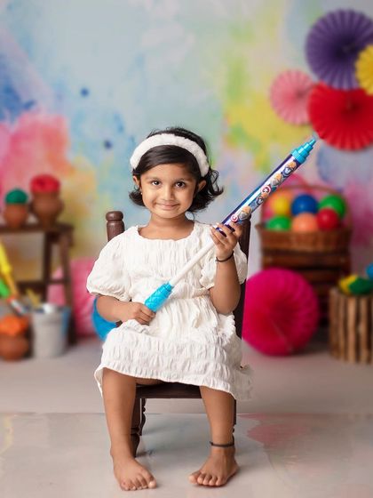 A little girl is all set for a colorful celebration in our vibrant Holi-themed studio.