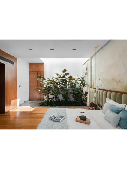 A bedroom in the Janani House opens into a private, light-filled courtyard. This design choice ensures a strong connection to nature and a serene personal retreat.