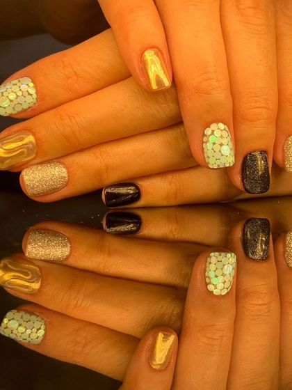 Another angle of the eclectic gold, black, and glitter short nail set.
