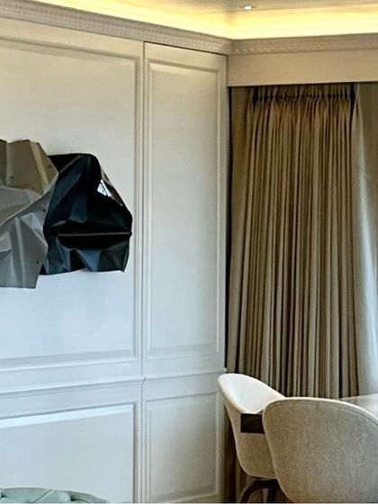 The texture of the wall paneling provides a perfect frame for the abstract sculpture.