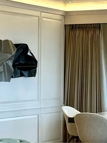 The texture of the wall paneling provides a perfect frame for the abstract sculpture.