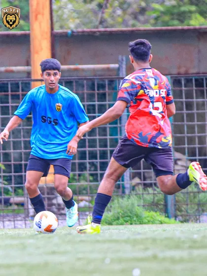 An SG5 player holding off a defender while advancing the ball, showcasing strength and determination.