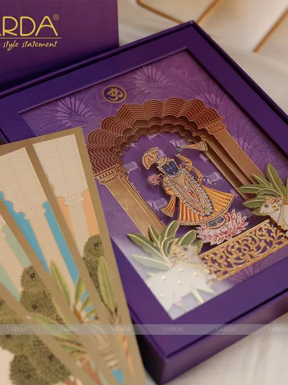 We designed this Shreenathji-themed wedding invitation box with divine artistry. The rich purple box opens to reveal a stunning 3D depiction of Lord Shrinathji, blending sacred tradition with luxurious, detailed craftsmanship for a truly memorable wedding announcement.