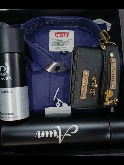 A coordinated gift set with a personalized wallet, keychain, and temperature bottle, paired with a dark blue shirt and deodorant.