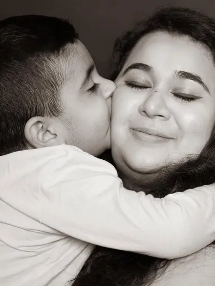 A sweet kiss on the cheek is a simple gesture filled with immense love. I aim to capture these tender interactions that highlight the special bond between a mother and her son.