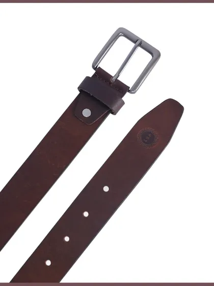 A detail shot of a leather belt, showing the buckle and the holes for adjustment.