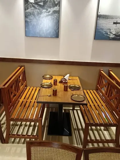 This seating arrangement features custom-made solid wood benches with a classic 'X' back design. This type of sturdy, slatted construction is ideal for high-traffic restaurant environments.