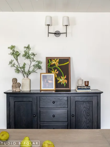 A close-up of the styled sideboard, where personal photos, art, and decorative objects come together to tell the family's story. These details are what make a house feel like a home.