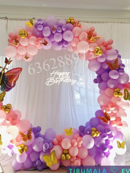 A beautiful butterfly themed circular balloon arch in shades of pink and purple, perfect for a photo backdrop.