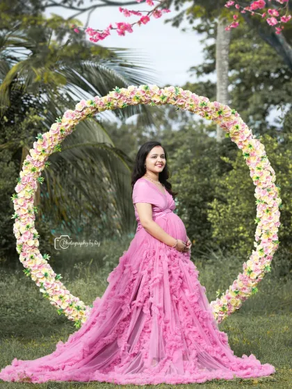 A beautiful solo portrait in a pink ruffled gown, framed by a circular floral prop.