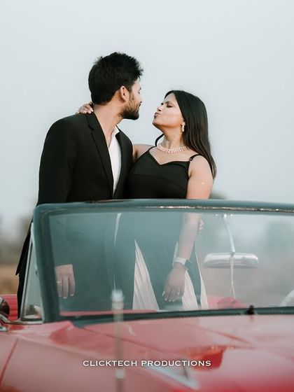 A playful and romantic close-up of a couple inside a vintage red convertible, capturing their fun-loving chemistry.