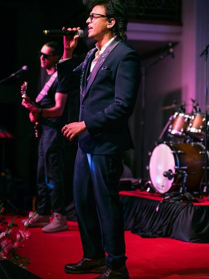 A full-stage view of singer Abhijeet Sawant performing in our classic three-piece tuxedo. A timeless look for any formal event.