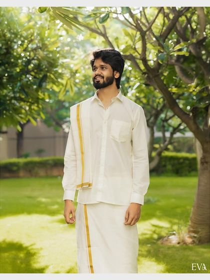 A portrait of the groom in his traditional white mundu, ready for the Haldi ceremony.