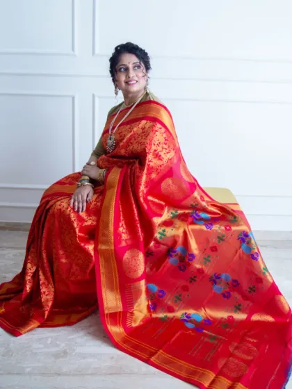 The sheer beauty of a handwoven red Paithani saree. In this studio shot, I focused on capturing the rich color and intricate gold work, with the model seated to let the fabric drape beautifully, showing its luxurious feel.