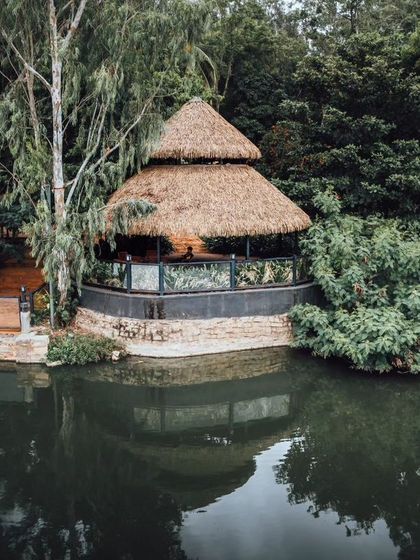 A charming thatched-roof hut by the lake, one of the many picturesque structures on the property.