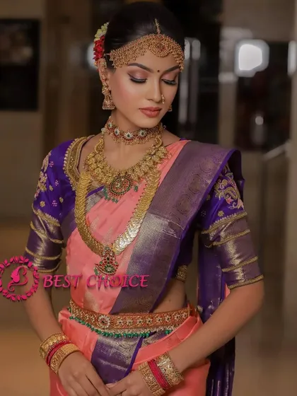 A model wearing a beautiful kasu malai set with a pink and purple saree, perfect for a wedding guest or bridesmaid.