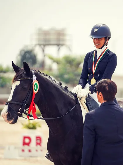 Another shot of a rider being awarded her gold medal for winning the Intermediate-1 dressage competition. These moments of success are what we work towards every day.