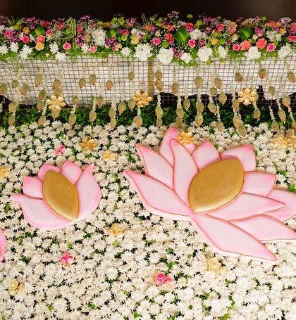 A wider view of the floral wall with lotus cutouts, showing how these elements are integrated into the overall stage design for a cohesive look.