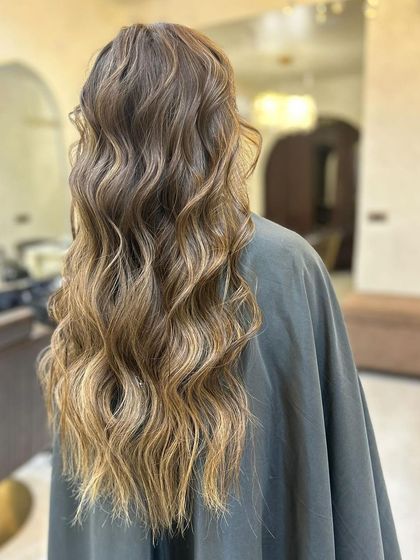 An olive ashy brown seamless balayage. The cool, earthy tones are blended perfectly from roots to ends for a sophisticated and modern look.