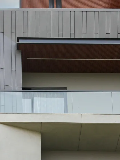 This close-up shows the material palette of the Akashneem Marg facade, with smooth concrete, textured panels, and wood-look ceilings creating a harmonious and modern look.