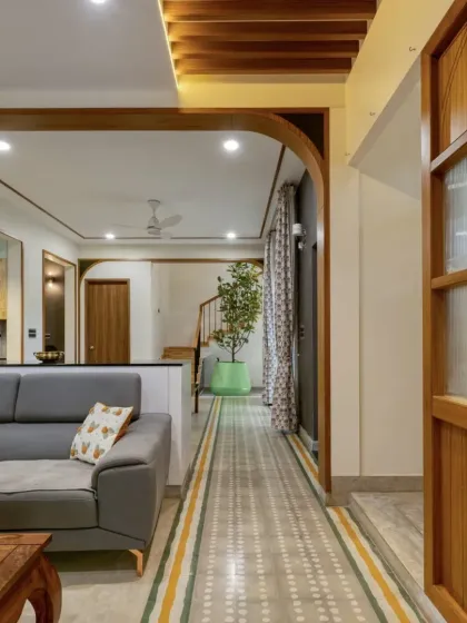 Wooden arches elegantly frame the transitions between the living room, dining area, and staircase, creating a cohesive and flowing space.