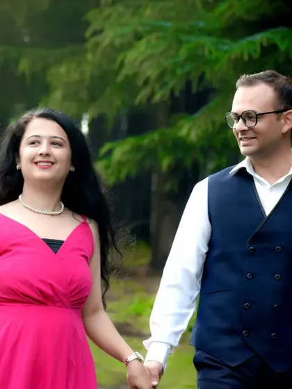 A happy couple walking hand-in-hand through a forest path. This candid style of pre-wedding photography is perfect for capturing natural interactions and real smiles.