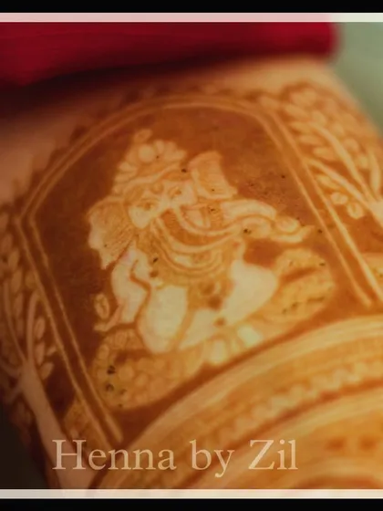 A macro shot of the Ganesha portrait after the henna paste has dried. This highlights the texture and precision of the artwork before the stain develops.