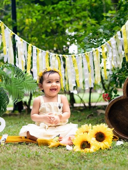 Pure happiness surrounded by sunflowers. This little one is celebrating her first birthday with a bright and cheerful outdoor theme.