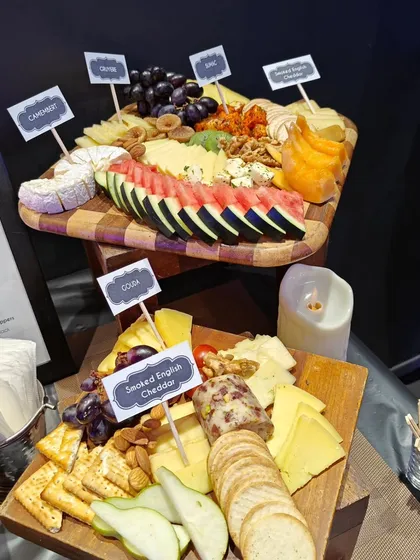 A top-down view of our cheese boards, clearly labeled for guest convenience. We offer a diverse selection, including Camembert, Gouda, and Smoked English Cheddar, paired with crackers, fruits, and nuts.